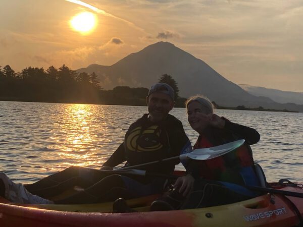 A couple kayaking on Dunlewey Lake at sunrise