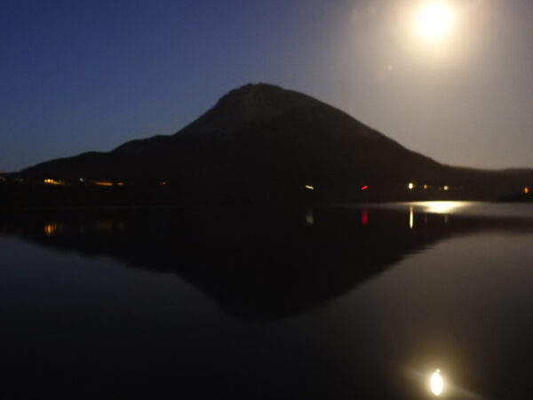 Kayaking on Dunlewey Lake with a view of mountain at dusk