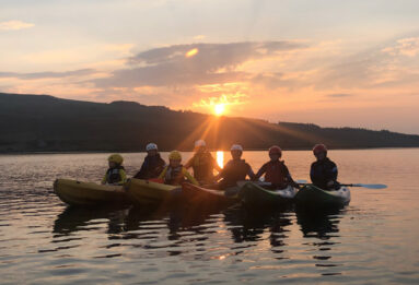 Kayaking at sunset with a group of young people on Dunlewey Lake